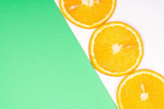 Colorful orange slices on a contrasting green and white backdrop, perfect for fresh themes.