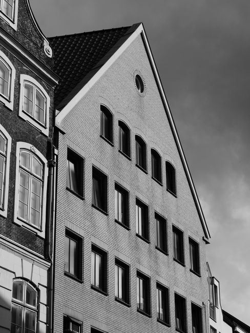 Black and white photo capturing historic architecture in Lübeck, Germany, featuring traditional gabled roofs.