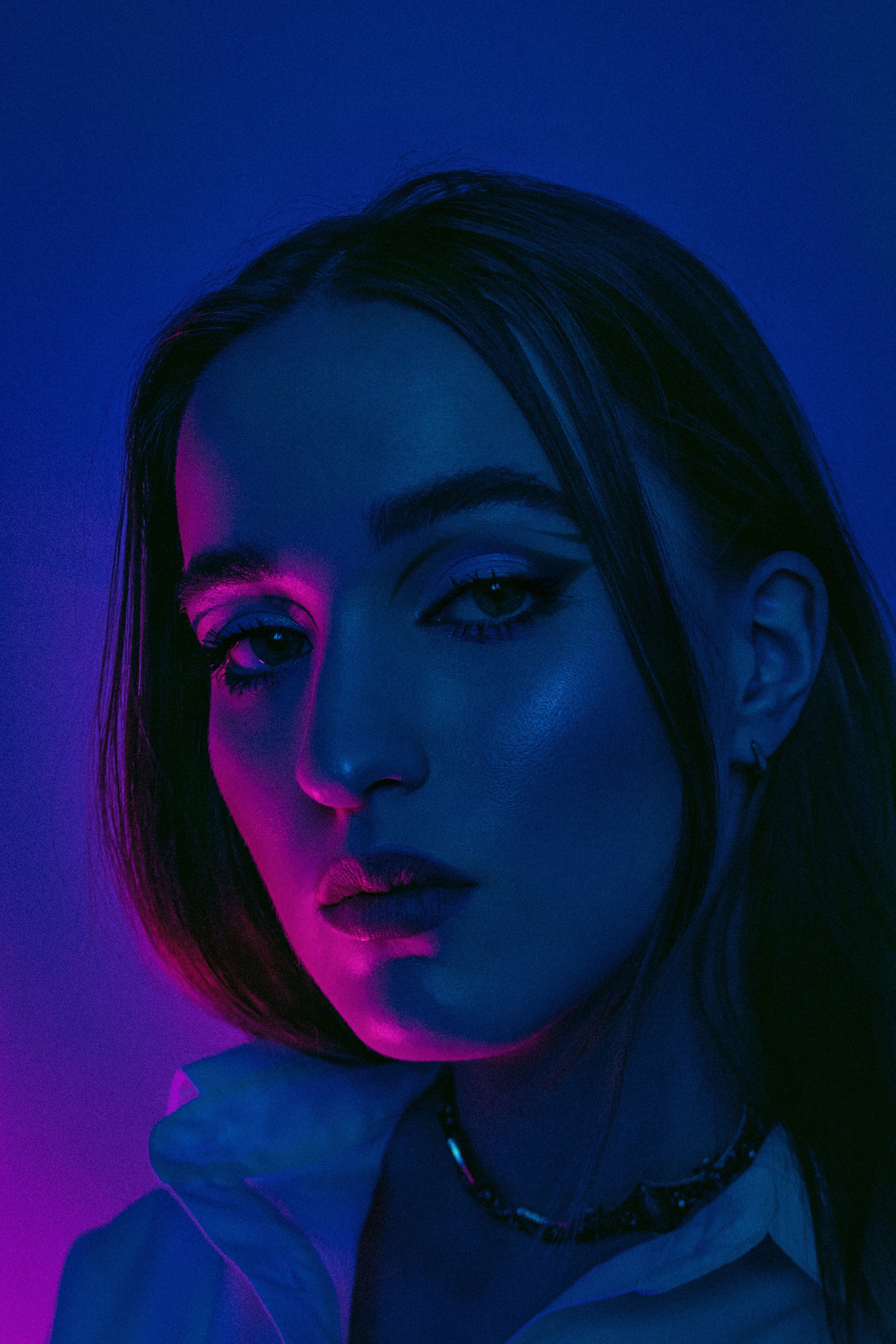 Portrait glamour d'une femme blonde dans une lumière néon rose et bleue