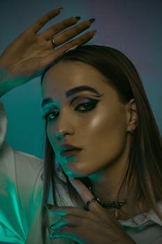 Close-up portrait of a woman showcasing bold, dramatic eye makeup and artistic lighting.