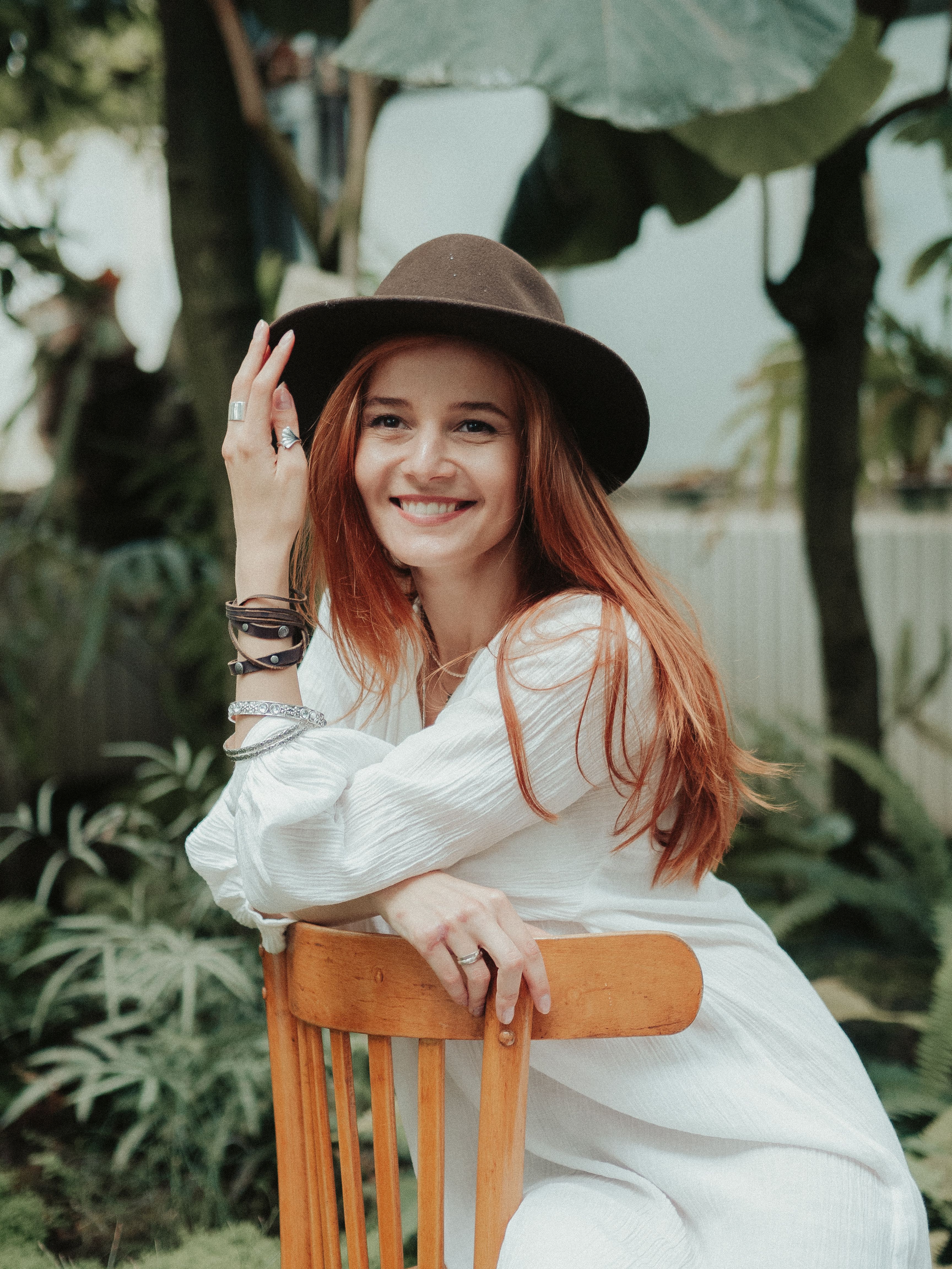 Woman in White Long Sleeve Dress Sitting on Wooden Chair · Free Stock Photo