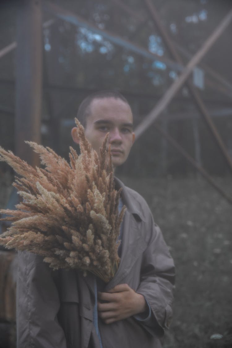 A Man Holding Dried Reeds