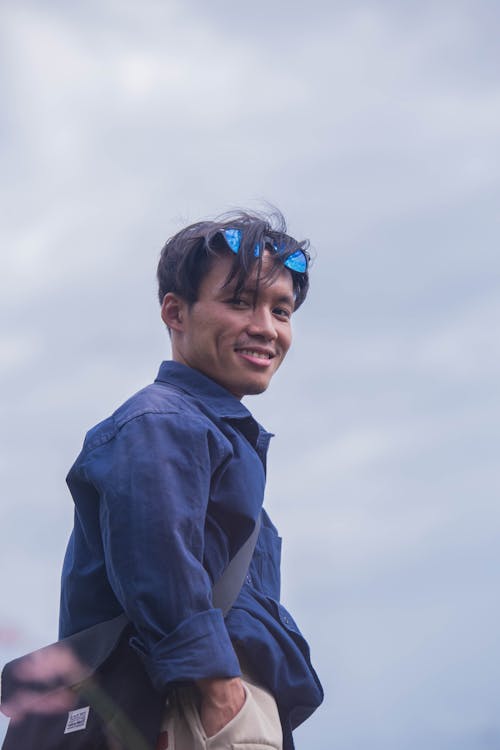 A Low Angle Shot of a Man in Blue Long Sleeves Smiling