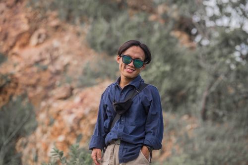 Free Smiling man in casual denim, wearing sunglasses, surrounded by nature. Stock Photo