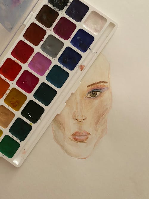 Watercolor Paints and a Watercolor Painting of a Human Face