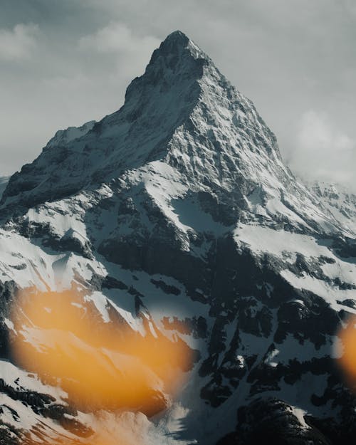 A Snow Covered Mountain Under the Cloudy Sky