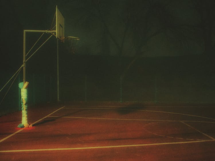 An Empty Basketball Court At Night