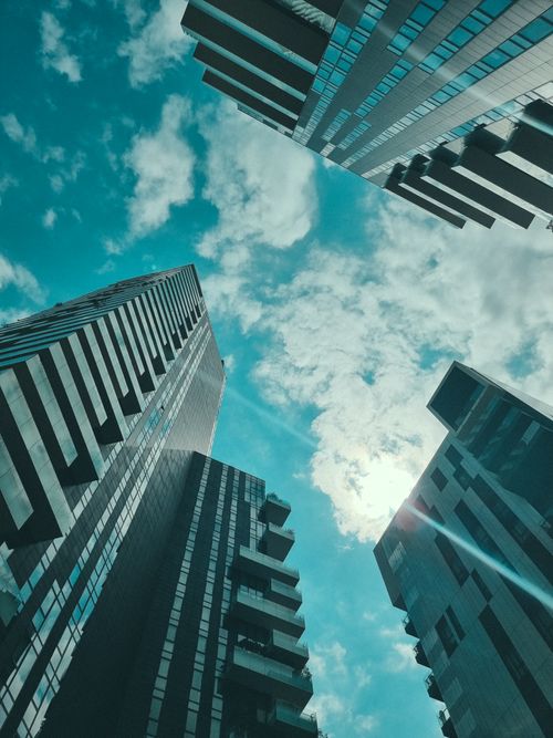 Free Low angle view of modern skyscrapers with a cloudy blue sky background. Stock Photo