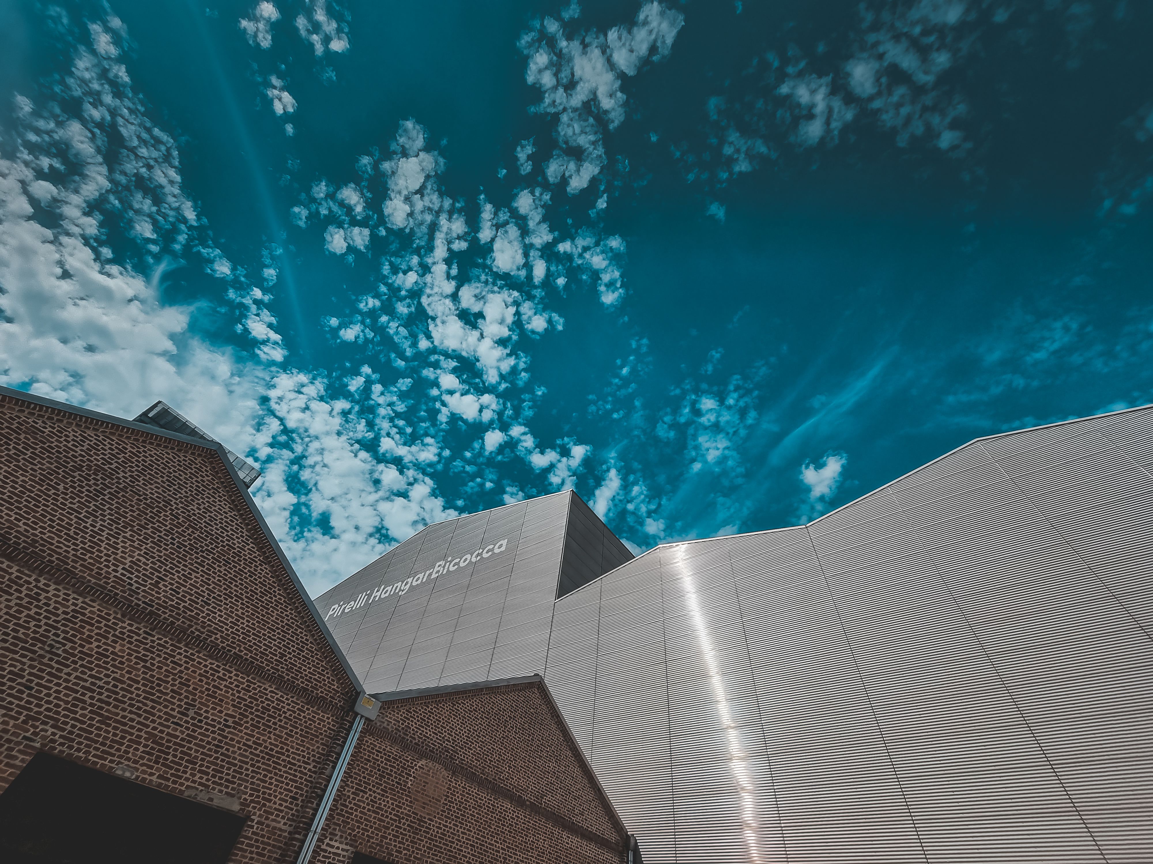 A Low Angle Shot of a Building Under the Blue Sky and White Clouds ...