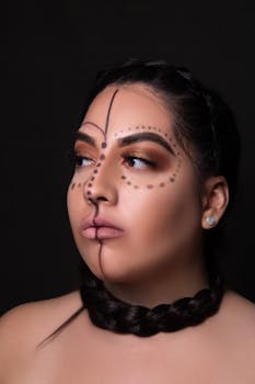 Striking close-up of a woman with creative makeup and braided hairstyle.