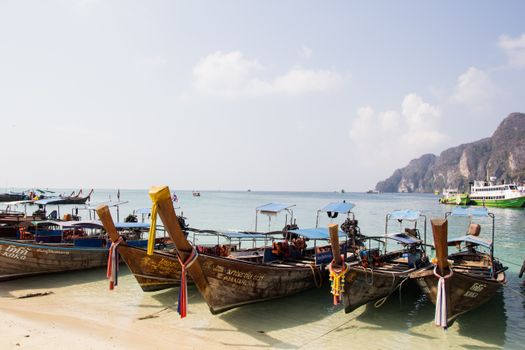 沙滩上停泊的长尾船风景优美，海水清澈，悬崖遥远