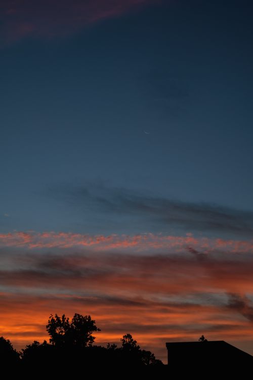 Free Capture the beauty of twilight with a crescent moon and silhouetted landscape. Stock Photo