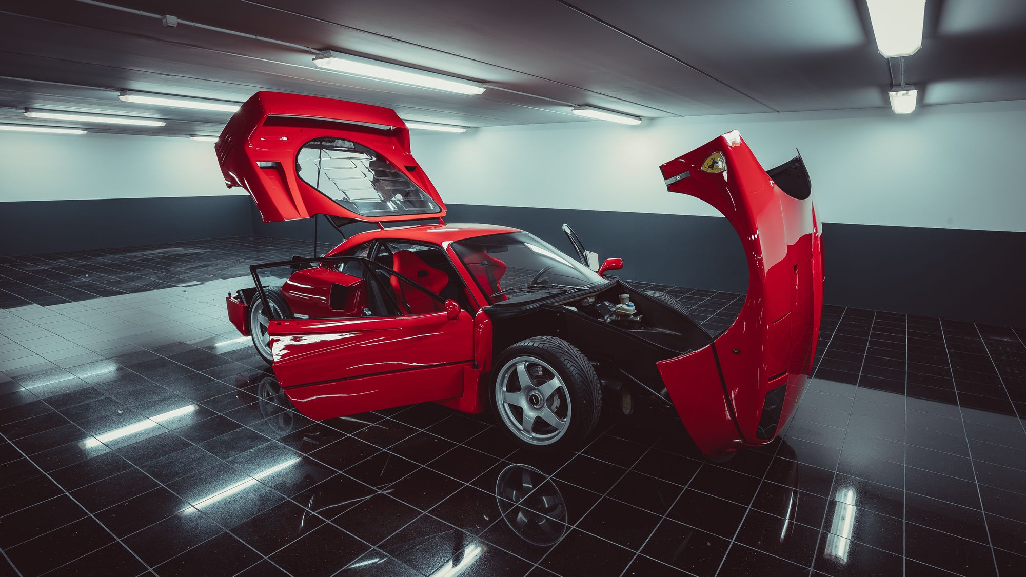 Red Ferrari F40 with hood and doors open in a garage setting directly supports a pre-purchase inspection narrative.