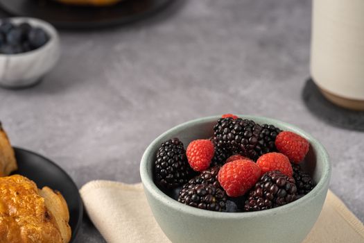 Close-up of a bowl with fresh raspberries and blackberries, perfect for healthy eating.