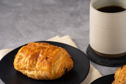 Free A Bread on Black Plate Near the Coffee on a Ceramic Mug Stock Photo