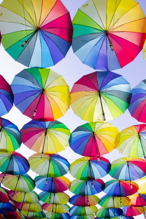 Free Colorful umbrellas arranged in a vibrant pattern create a striking canopy against a clear blue sky. Stock Photo