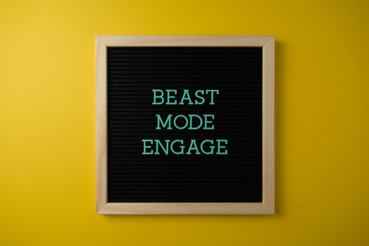 Inspirational letter board with 'Beast Mode Engage' text on vibrant yellow background for motivation.