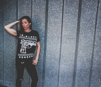 Woman Leaning on Gray Wall While Holding Hair