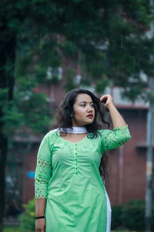 Woman in Green Long Sleeve Dress Holding Her Hair 