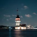 White and Brown Concrete Building Near Body of Water during Night Time