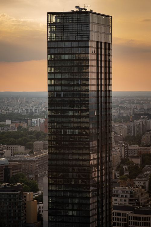Free Tall skyscraper in a city skyline at sunset, showcasing modern architecture and urban landscape. Stock Photo