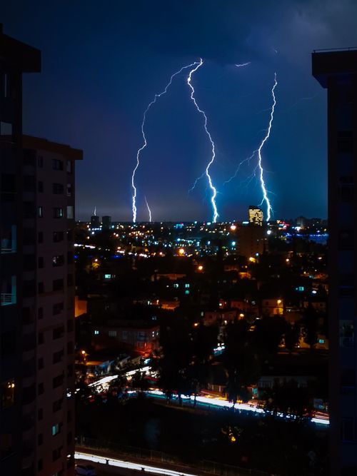 Free Dynamic lightning strikes illuminate urban night skyline, capturing the power of nature. Stock Photo