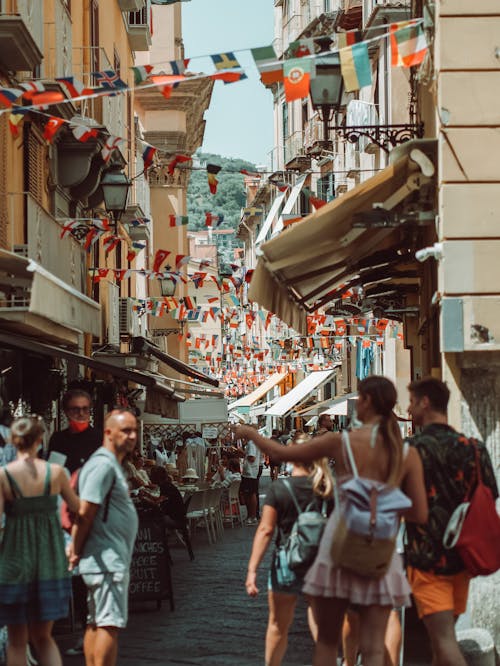 People Walking in the Crowded Street in Front of the Shops