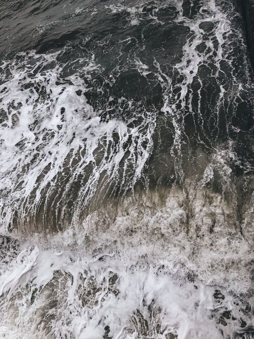Free Aerial shot of powerful ocean waves crashing with foamy texture, showcasing natural beauty and motion. Stock Photo