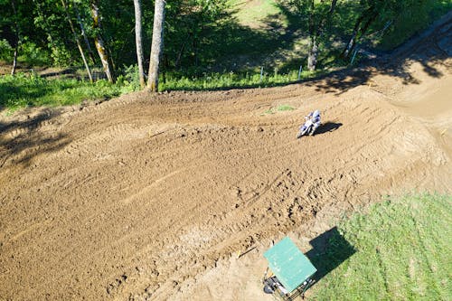 A Person Riding an Off-road Bike on the Dirt Track
