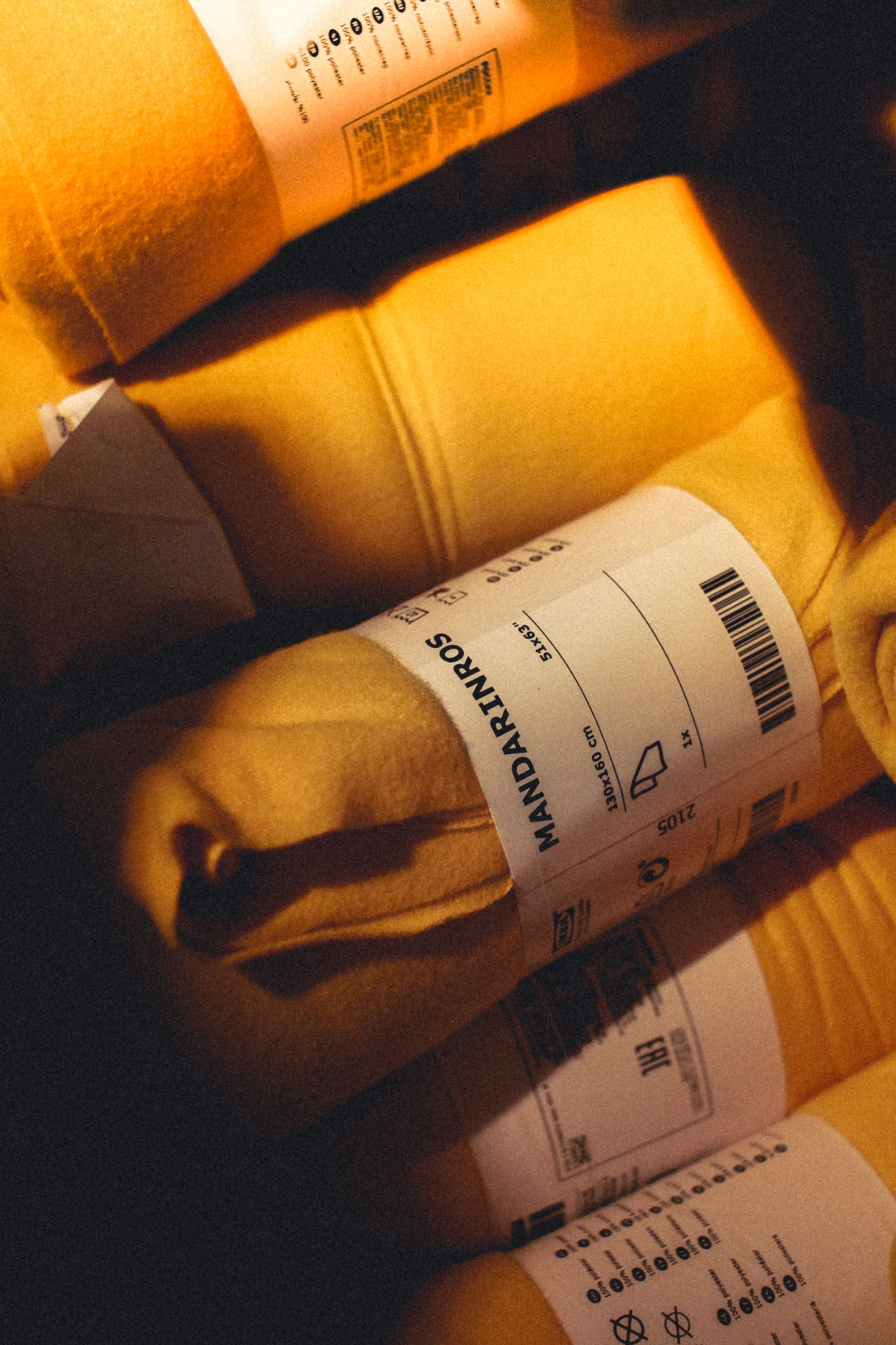 A close-up view of rolled yellow blankets with visible labels and barcodes.