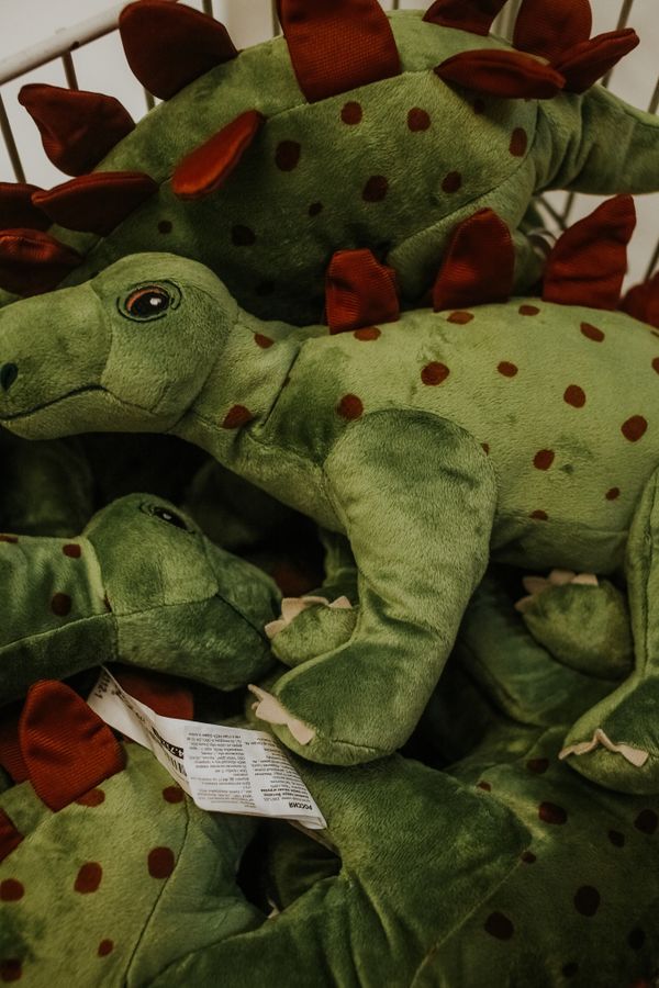 A pile of green dinosaur plush toys — photo by Nikita Nikitin on Pexels