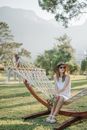 Woman in White Tank Top Sitting on White Hammock
