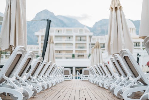 Free Sun Loungers and Beach Umbrellas on a Wooden Deck Stock Photo