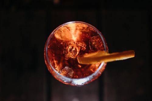 Free A top-down view of a vibrant orange cocktail with ice and a citrus twist garnish in a glass. Stock Photo