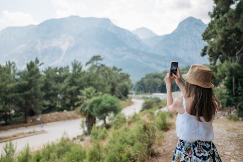 A Woman in White Tank Top Taking Photos