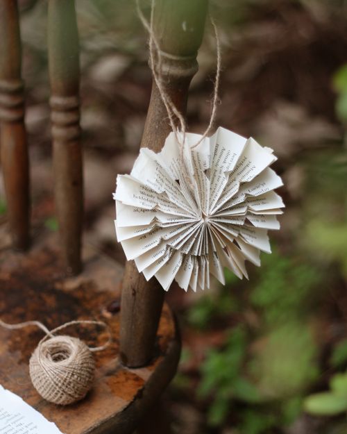 Free Handcrafted paper decoration hanging on a vintage chair with yarn in a serene outdoor setting. Stock Photo