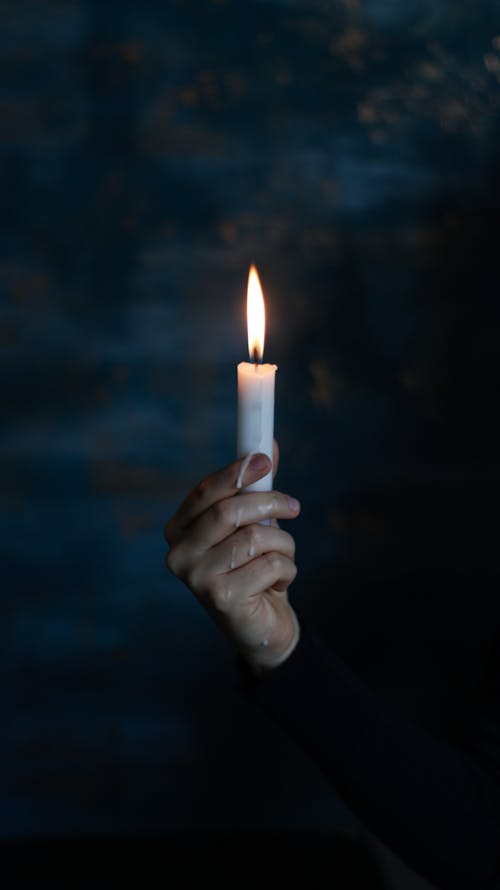 Person Holding White Lighted Candle