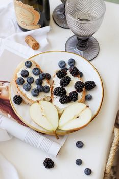 Delicious open-faced sandwich with blueberries, blackberries, and pear on a plate.