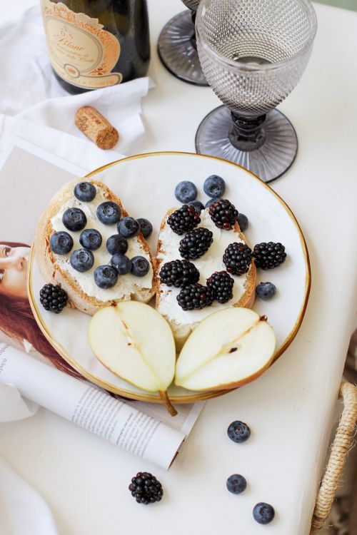 Free Delicious open-faced sandwich with blueberries, blackberries, and pear on a plate. Stock Photo