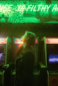 Blurred image of a neon-lit arcade setting with retro gaming machines, evoking 80s nostalgia.