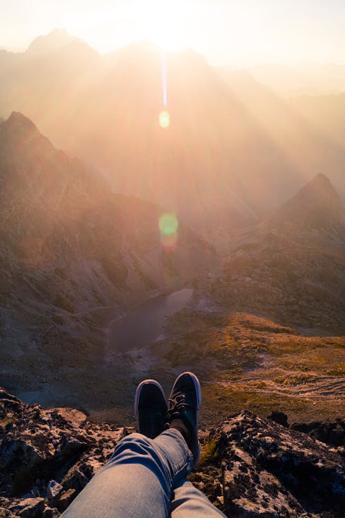 Orang Mengenakan Sepatu Sneaker Hitam Duduk Di Gunung