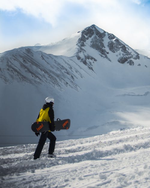 Snowboarder Walking on Snow-Covered Ground