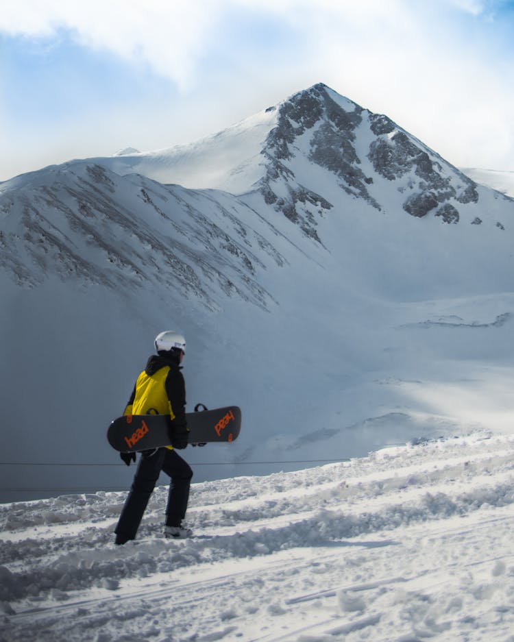 Snowboarder Walking On Snow-Covered Ground