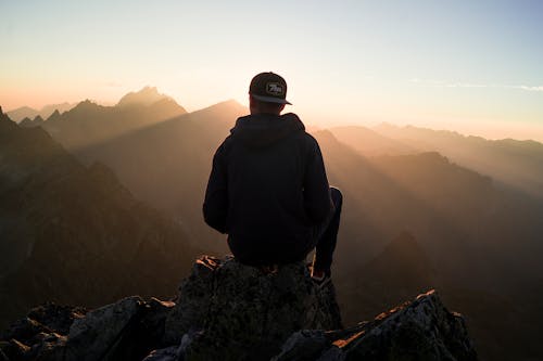 Free Man Sitting on the Mountain Edge Stock Photo