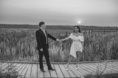 Free A Couple Standing on the Wooden Bridge Stock Photo