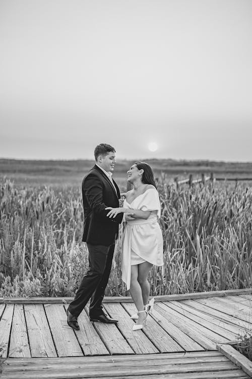Man and Woman Standing on the Wooden Pathway