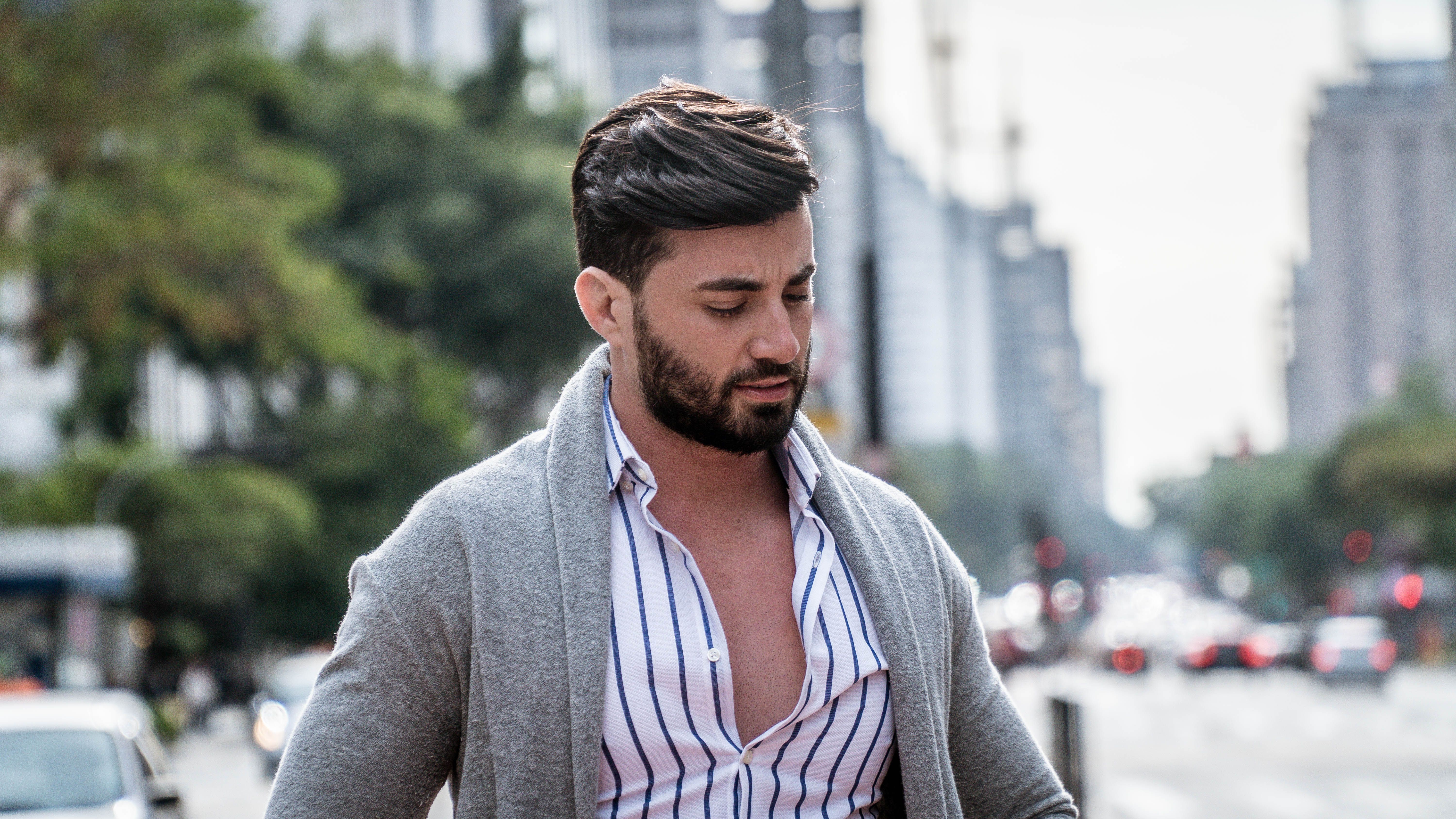 Homme en cardigan gris à col châle porté sur une chemise rayée, en ville