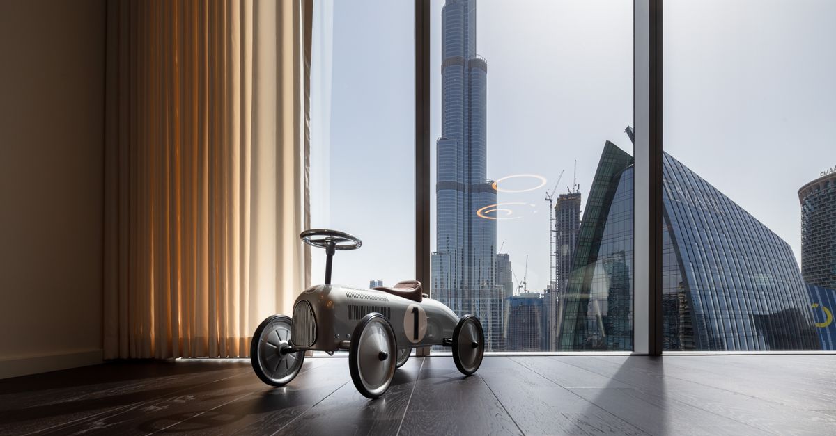 Vintage toy car in modern setting with Dubai's iconic skyline view, featuring Burj Khalifa.