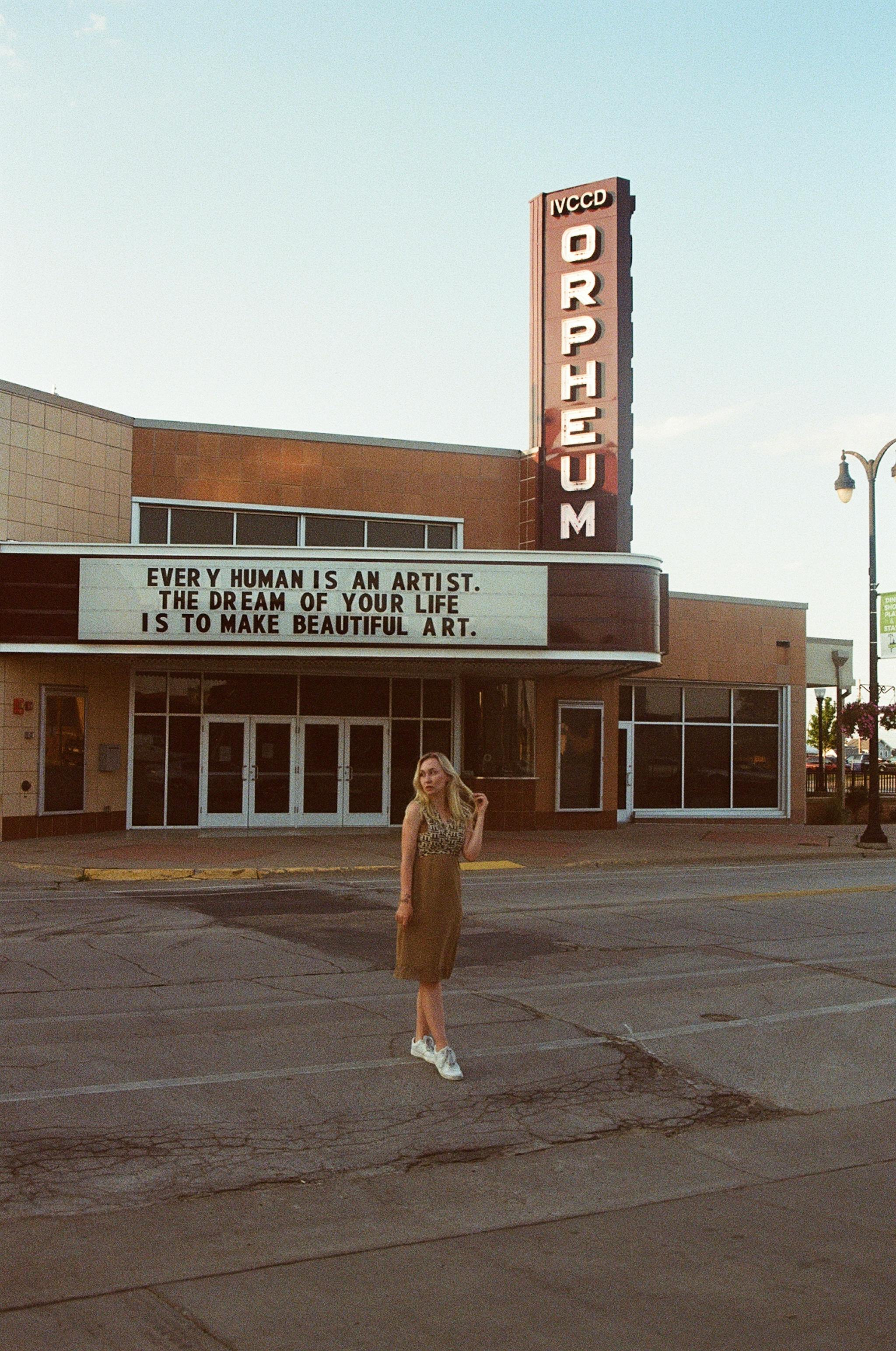 Free A woman stands in front of the Orpheum Theater on a sunny day. Stock Photo