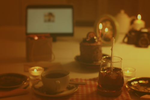 Free A warm, moody still life of a workspace featuring coffee, cake, and candles for a cozy ambiance. Stock Photo